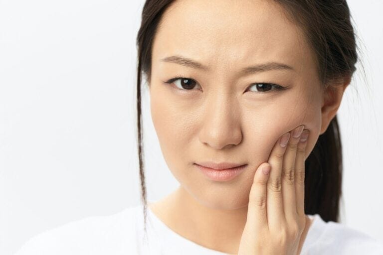 Gumboil Dental abscess Wisdom teeth Periodontitis. Unhappy suffering tanned pretty young Asian woman