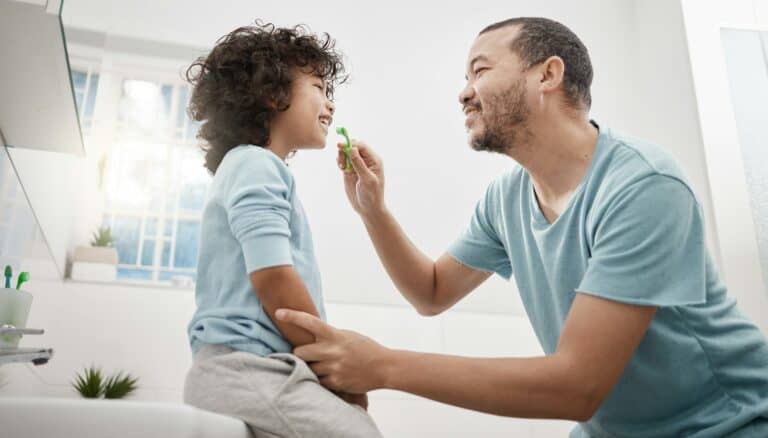 Shot of a father brushing his little sons teeth in the bathroom at home